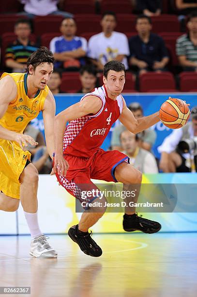 Roko-Leni Ukic of Croatia drives the ball upcourt followed by Andrew Bogut of Australia during the day 2 preliminary game at the Beijing 2008 Olympic...