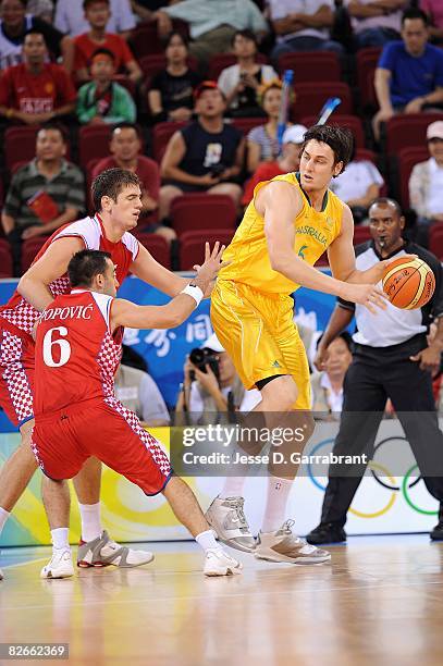 Andrew Bogut of Australia looks for an open pass over Marko Popovic and Marko Banic of Croatia during the day 2 preliminary game at the Beijing 2008...
