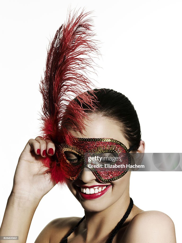 Petite fille portant masque sequinned, regardant vers le bas