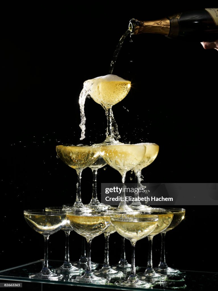 Hand pouring a champagne fountain