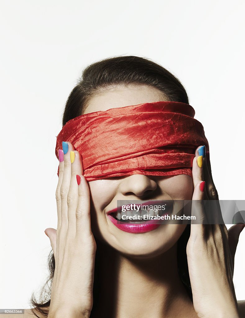 Blindfolded girl with bright nail polish