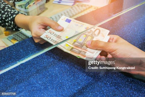 female hand with money in cash department window. currency exchange concept. euro banknote. eur . cash on counter bank. hand giving cash and hand receiving cash. payday paying cashier access - women euro 2017 stock-fotos und bilder