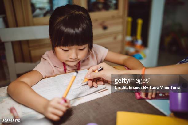 first person view of mom teaching little daughter doing homework. - chinese tutor study stock pictures, royalty-free photos & images