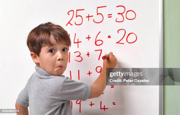 pupil baffled by maths sum on classroom whiteboard - wiskunde stockfoto's en -beelden
