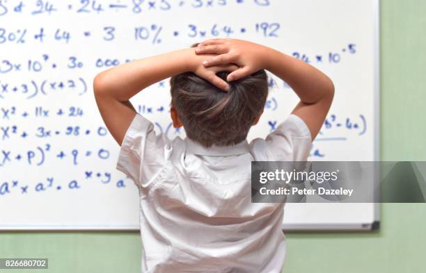 junior pupil amazed by maths on classroom whiteboard - thinking outside the box englische redewendung stock-fotos und bilder