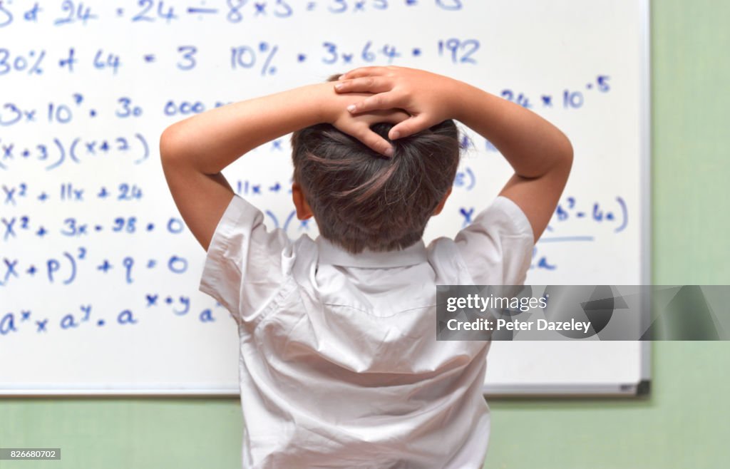 JUNIOR PUPIL AMAZED BY MATHS ON CLASSROOM WHITEBOARD
