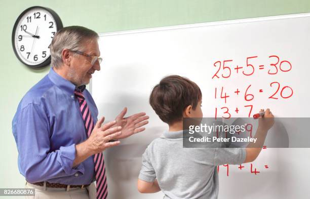teacher explaining maths to junior pupil - thinking outside the box englische redewendung stock-fotos und bilder