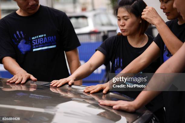 Participant with hand placed on a car during of the Subaru Palm Challenge in Bangkok, Thailand, on August 5, 2017. Subaru Palm Challenge Thailand...