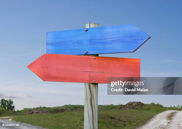 blue & red direction signs. - opposite direction stockfoto's en -beelden