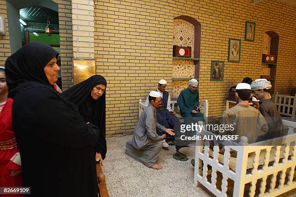 Visitors observe a cafe scene set up in the recently re-opened Al-Baghdadi Museum in the Iraqi capital Baghdad on September 1, 2008. The museum...