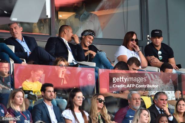 Paris Saint-Germain's Brazilian forward Neymar , flanked by his father Neymar Santos , mother Nadine Santos and a close friend Jo Amancio , reacts...