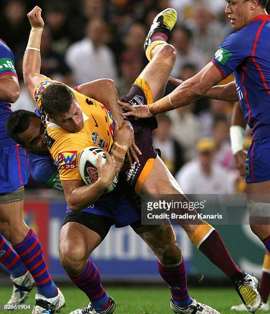 Ashton Sims of the Broncos is tackled during the round 26 NRL match between the Brisbane Broncos and the Newcastle Knights held at Suncorp Stadium on...