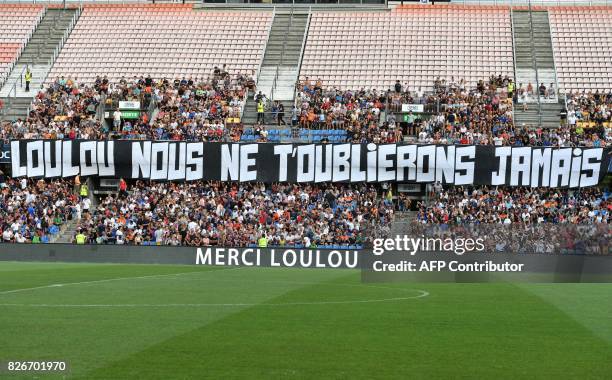 Montpellier supporters hold a banner reading "Loulou we will never forget you" in tribute to Montpellier's late president Louis Nicollin prior to the...