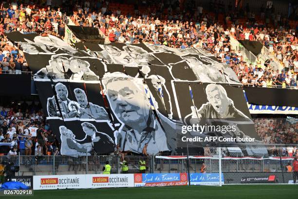 Supporters hold banners in tribute to Montpellier's late president Louis Nicollin prior to the French L1 football match between Montpellier and Caen...