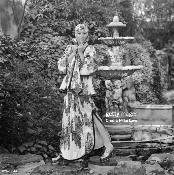 Model Jill Harley wearing a printed satin outfit with leather trim, by British designer Bill Gibb, at a fashion show at Les Ambassadeurs, London,...