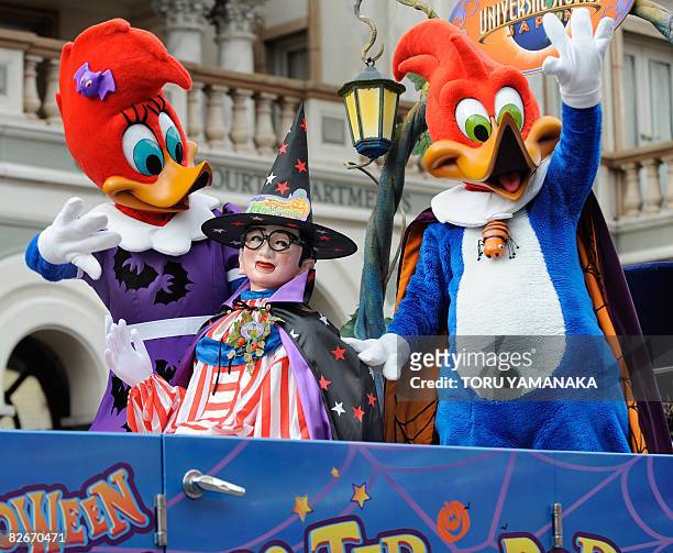 People clad in Halloween costumes, Woody Woodpecker , Winnie Woodpecker and local famous charachter "Kuidaore Taro" wave to the audience from a...