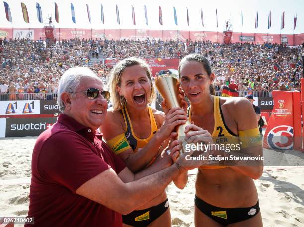 Gold medalist Laura Ludwig and Kira Walkenhorst of Germany receive their winners trophy from the Dr. Ary S. Graca President of FIVB during the medal...