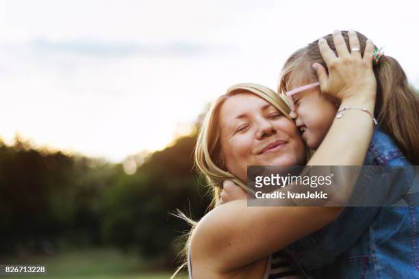 moeder en dochter onvoorwaardelijke liefde - kissing kids stockfoto's en -beelden