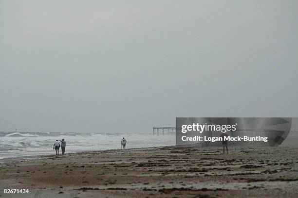 Beachgoers look out over the waves and clutter caused by Tropical Storm Hannah on September 5, 2008 at Wrightsville Beach, North Carolina. The storm...