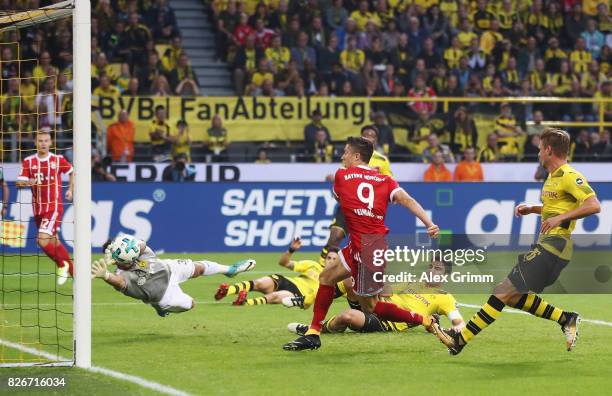 Robert Lewandowski of Muenchen scores his team's first goal past goalkeeper Roman Buerki of Dortmund during the DFL Supercup 2017 match between...