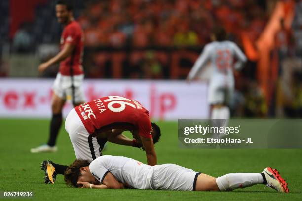 Ataru Esaka of Omiya Ardija and Ryota Moriwaki of Urawa Red Diamonds react after their collision during the J.League J1 match between Urawa Red...