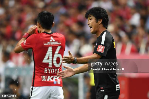 Head coach Takafumi Hori of Urawa Red Diamonds gives instruction to Ryota Moriwaki during the J.League J1 match between Urawa Red Diamonds and Omiya...