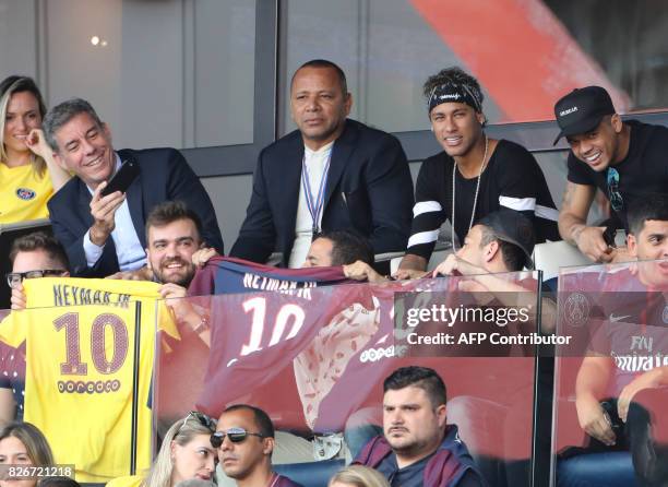 Paris Saint-Germain's Brazilian forward Neymar , flanked by his father Neymar Santos and a close friend Jo Amancio , watches the French L1 football...
