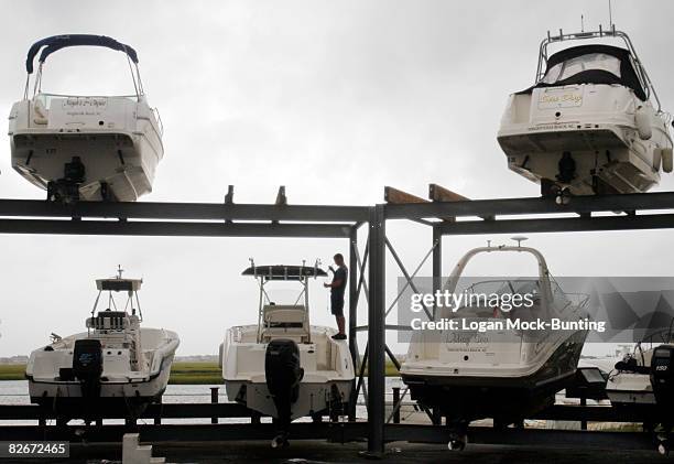 An employee at Marine Max Marina prepares boats in dry-dock for winds and rains anticipated with the arrival of Tropical Storm Hannah September 5,...