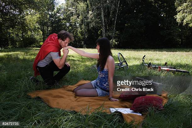 young couple at the park, he is kissing her hand. - kissing hand stock pictures, royalty-free photos & images