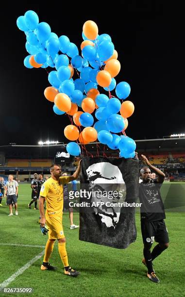 Montpellier's Senegalese forward Souleymane Camara and Montpellier's French goalkeeper Laurent Pionnier hold a portrait of Montpellier's late...