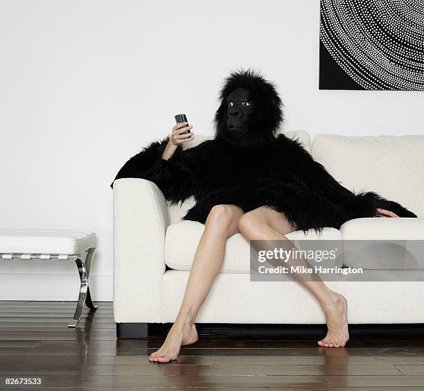 young woman dressed in gorilla suit using mobile - female monkey costume stock pictures, royalty-free photos & images
