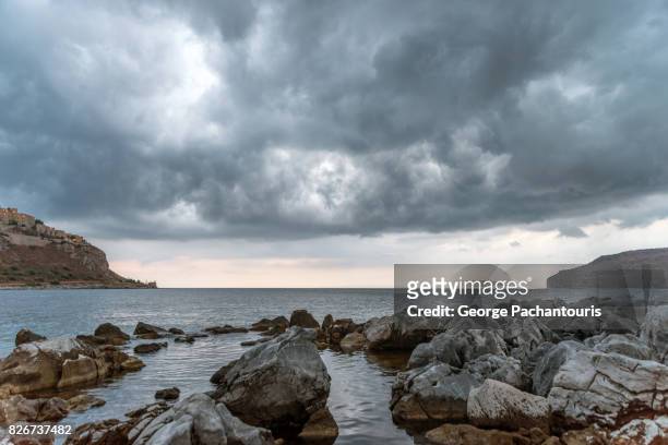dark clouds and rocks - littoral rocheux photos et images de collection