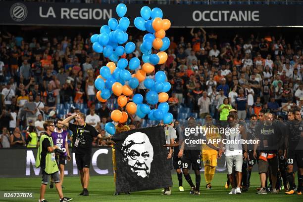 Montpellier's players hold a portrait of Montpellier's late president Louis Nicollin after the French L1 football match between MHSC Montpellier and...