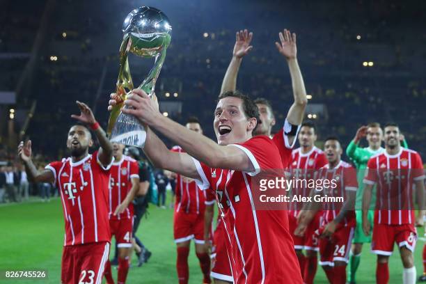 Sebastian Rudy of Muenchen celebrates with the trophy after his team won the DFL Supercup 2017 match between Borussia Dortmund and Bayern Muenchen at...