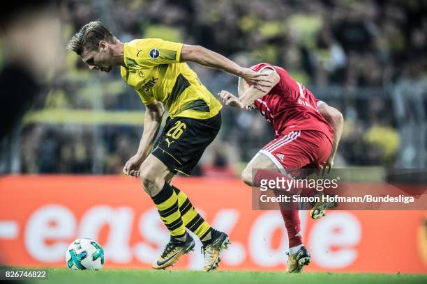 Lukas Piszczek of Dortmund is tackled by Franck Ribery of Muenchen during the DFL Supercup 2017 match between Borussia Dortmund and Bayern Muenchen...