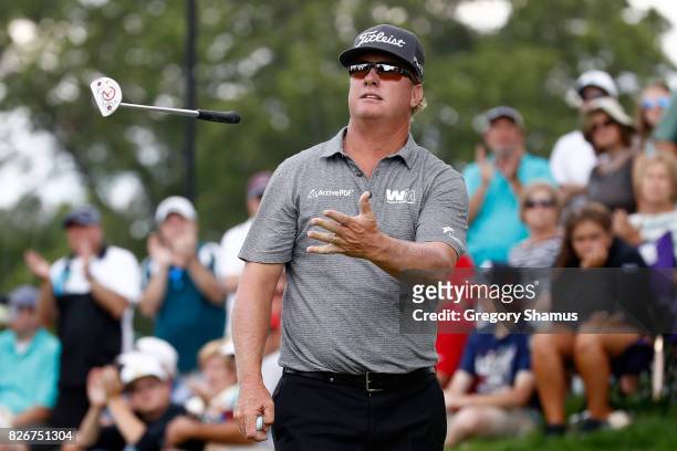 Charley Hoffman throws his putter to his caddie on the 12th green during the third round of the World Golf Championships - Bridgestone Invitational...