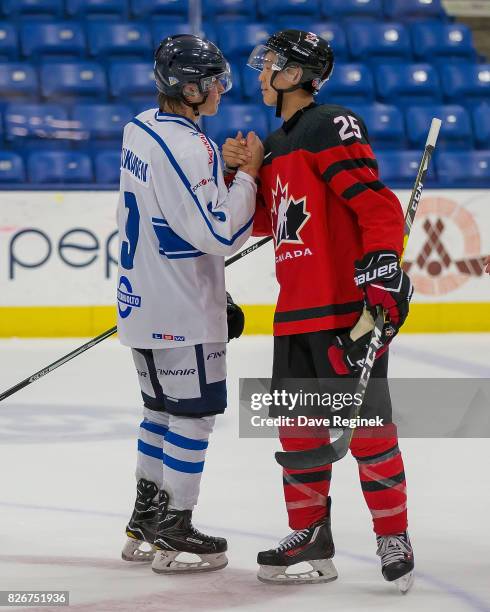 Cliff Pu of Canada shakes hands with Janne Kuokkanen of Finland after a World Jr. Summer Showcase game at USA Hockey Arena on August 2, 2017 in...