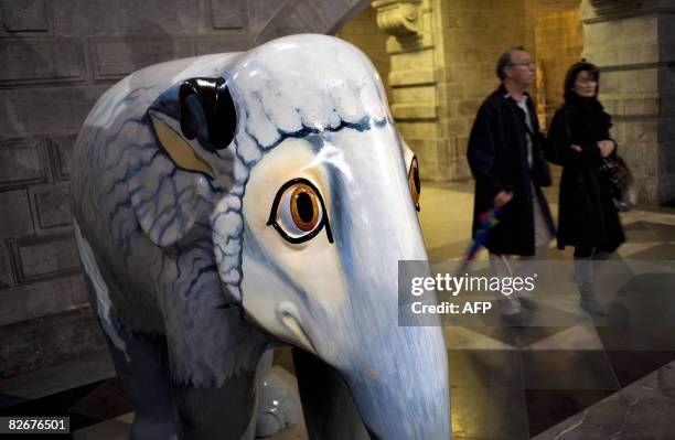 Couple walks past an sculpture of an elephant on September 5 the official opening day of the Elephant Parade in Antwerp. More than 70 elephants'...