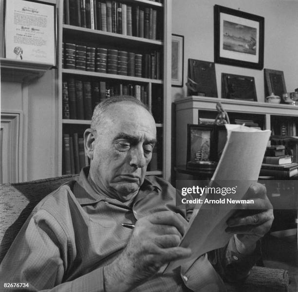 American city planner Robert Moses takes notes as he sits in his office, New York, New York, April 8, 1964.