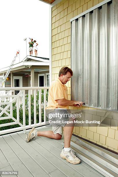 David Manning installs metal storm shutters in preparation for winds and rains anticipated with the arrival of Tropical Storm Hannah September 5,...