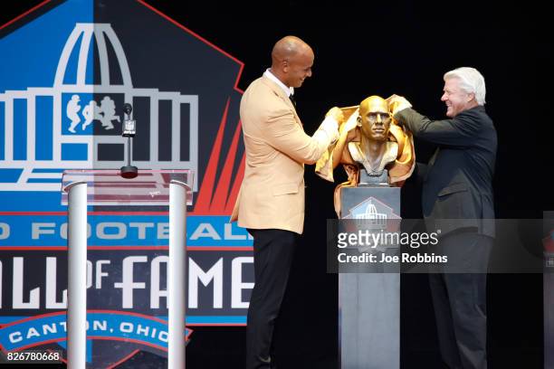 Jason Taylor and presenter Jimmie Johnson unveil Taylor's bust during the Pro Football Hall of Fame Enshrinement Ceremony at Tom Benson Hall of Fame...