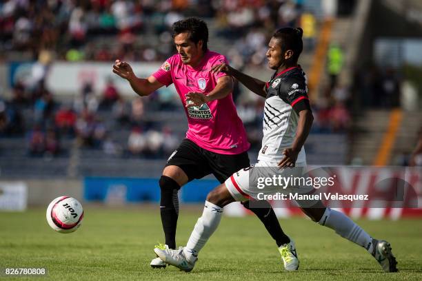 Jorge Hernandez of Pachuca struggles for the ball with Pedro Aquino of Lobos BUAP during the third round match between Lobos BUAP and Pachuca as part...