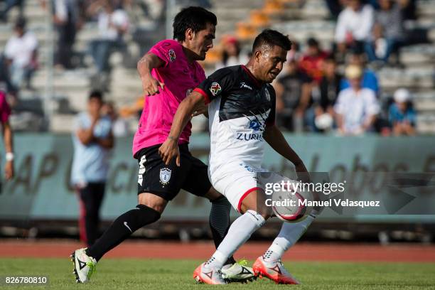Juan Medina of Lobos BUAP struggles for the ball with Jorge Hernandez of Pachuca during the third round match between Lobos BUAP and Pachuca as part...
