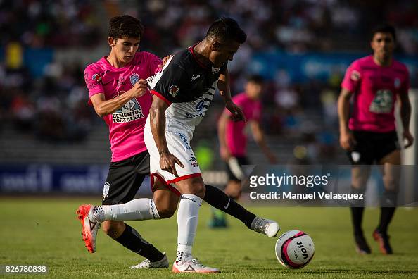 Francisco Figueroa of Pachuca struggles for the ball with Juan Medina ...