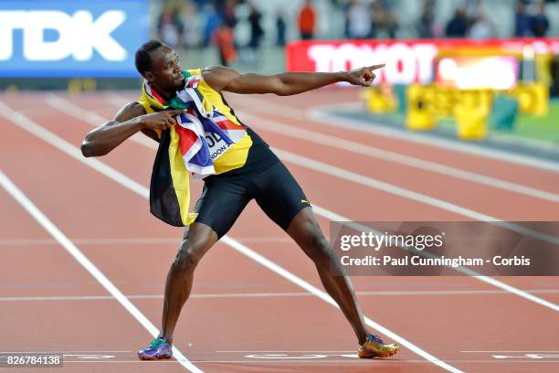 Usain Bolt of Jamaica having run his last 100m race, stands with both the Jamaican and Union Jack flag around his neck and pulls into his famous...