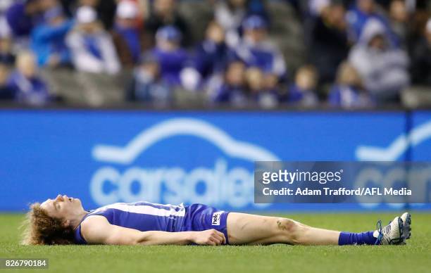 Ben Brown of the Kangaroos lays on the ground after being tackled by Brodie Grundy of the Magpies during the 2017 AFL round 20 match between the...