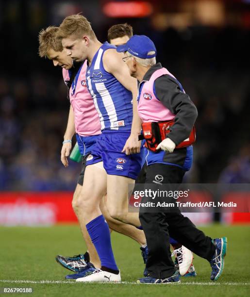 Jack Ziebell of the Kangaroos comes off the ground injured after a heavy clash during the 2017 AFL round 20 match between the North Melbourne...