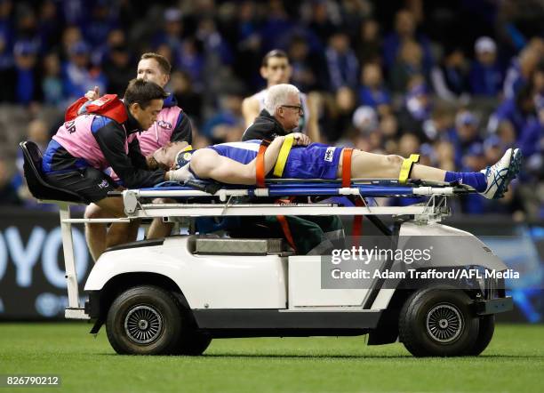 Ben Brown of the Kangaroos comes off the ground injured after being tackled by Brodie Grundy of the Magpies during the 2017 AFL round 20 match...