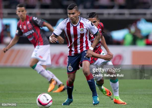 Orbelin Pineda of Chivas fights for the ball with Luis Perez of Necaxa during the third round match between Chivas and Necaxa as part of the Torneo...