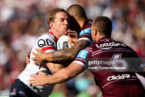 Mitchell Aubusson of the Roosters is tackled during the round 22 NRL match between the Manly Warringah Sea Eagles and the Sydney Roosters at...